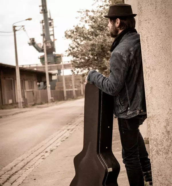 man with a guitar case